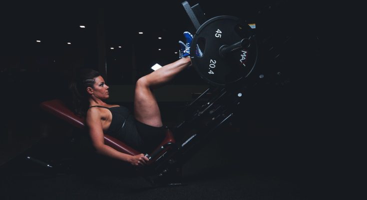 A woman engages in an intense leg press workout at the gym, showcasing strength and fitness. — Fitness Can Help To Eliminate