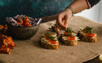 Close-up of a hand preparing artisan multigrain sandwiches with cheese and tomatoes. — What Food Enables You To Fat: How you